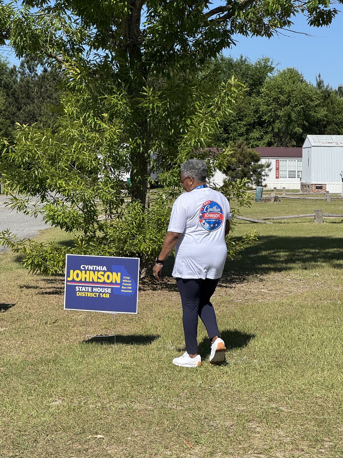 Cynthia Johnson placing a campaign yard sign in the district