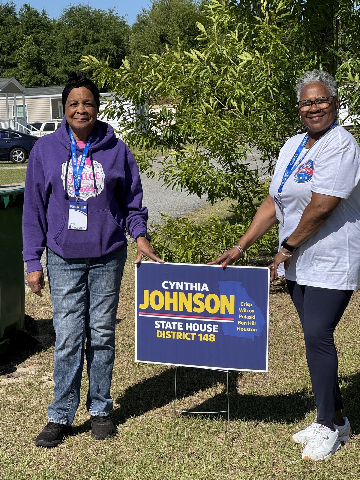 Cynthia Johnson and a volunteer with a District 148 yard sign