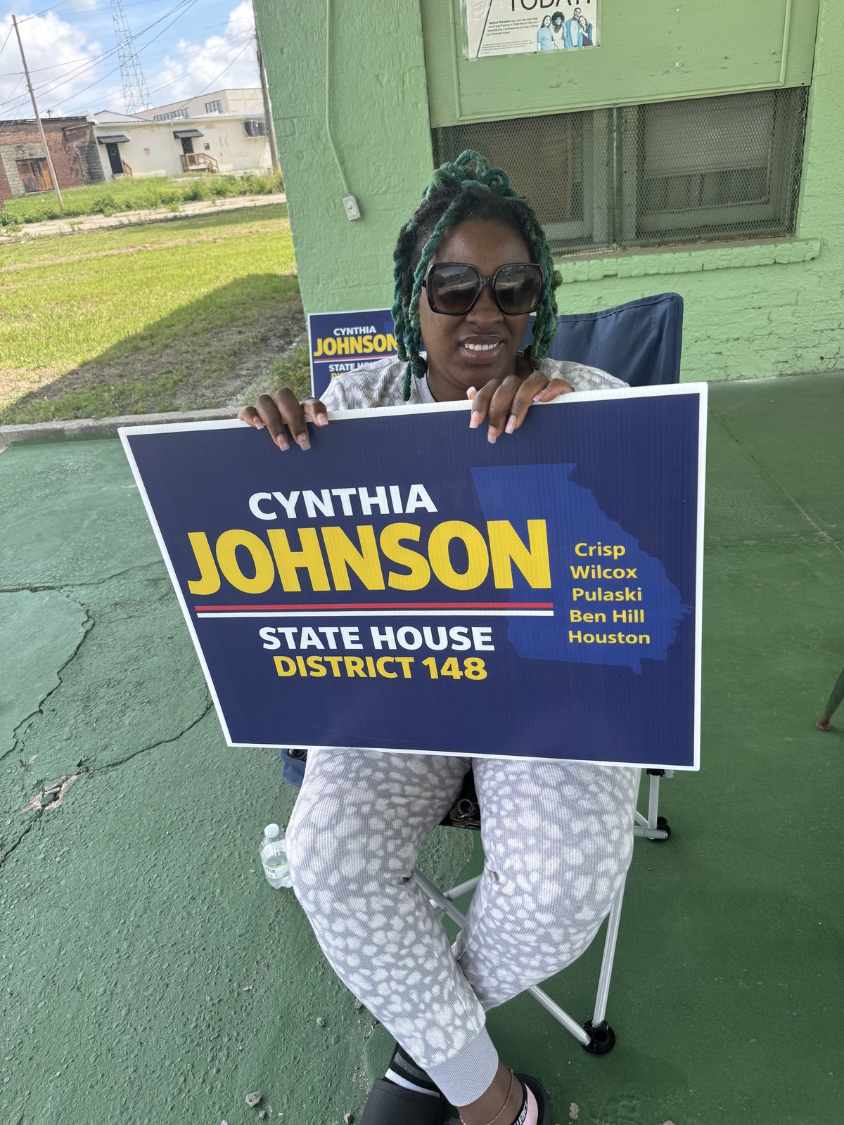 Cynthia Johnson holding a District 148 yard sign